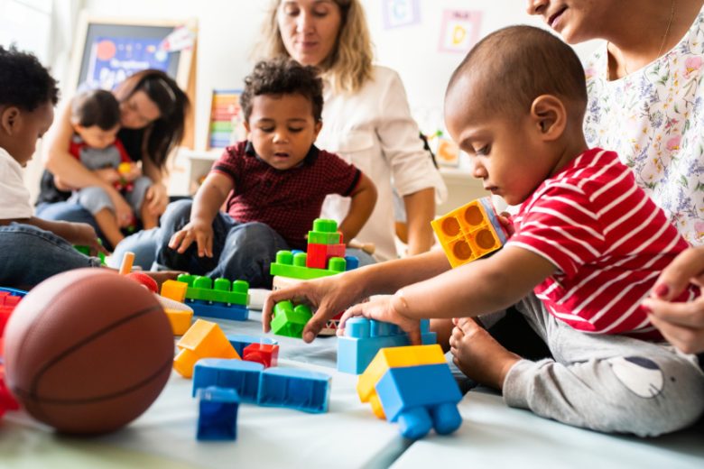 Parent and child foster carers with babies and toddlers playing with toys at a play group